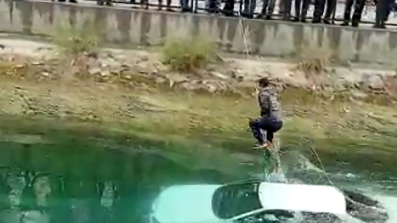 Otomobil kanala uçtu: Araç üzerine çıkan sürücü halatla kurtarıldı
